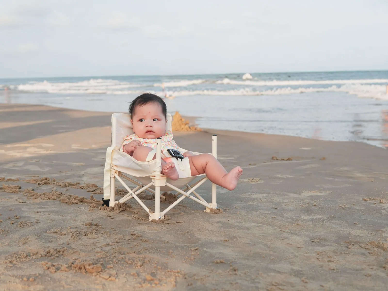 Essential baby gear for air travel laid out on a wooden floor.