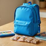 An organized holiday travel pack for kids sits on a wooden table.