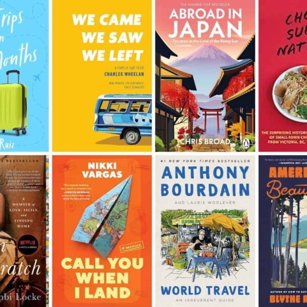 A selection of travel-themed picture books displayed on a wooden table in a sunny room.