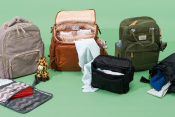 Compact travel diaper bag on a wooden table in a bright nursery.