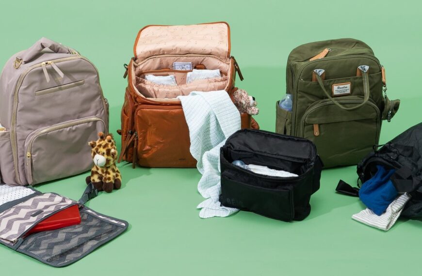 Compact travel diaper bag on a wooden table in a bright nursery.