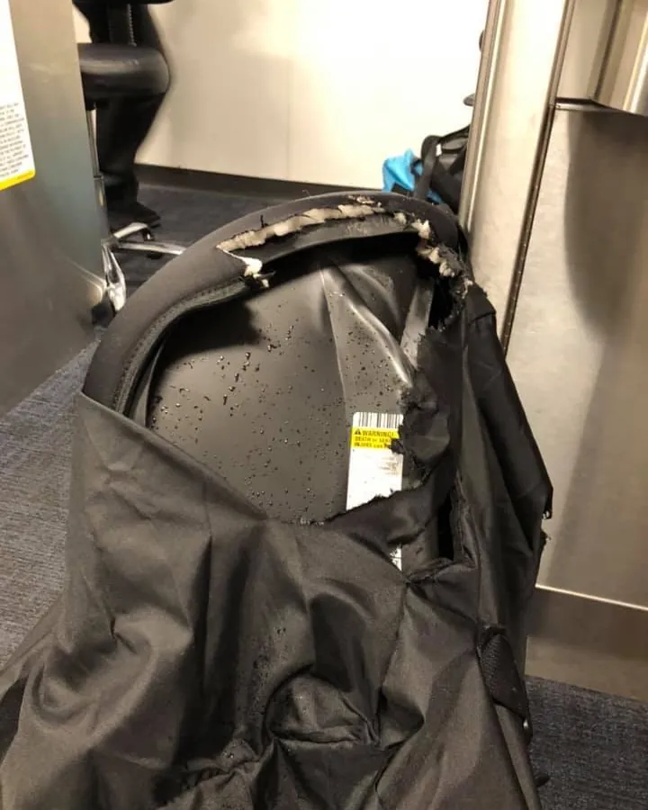 Cracked car seat with frayed harness on a living room floor